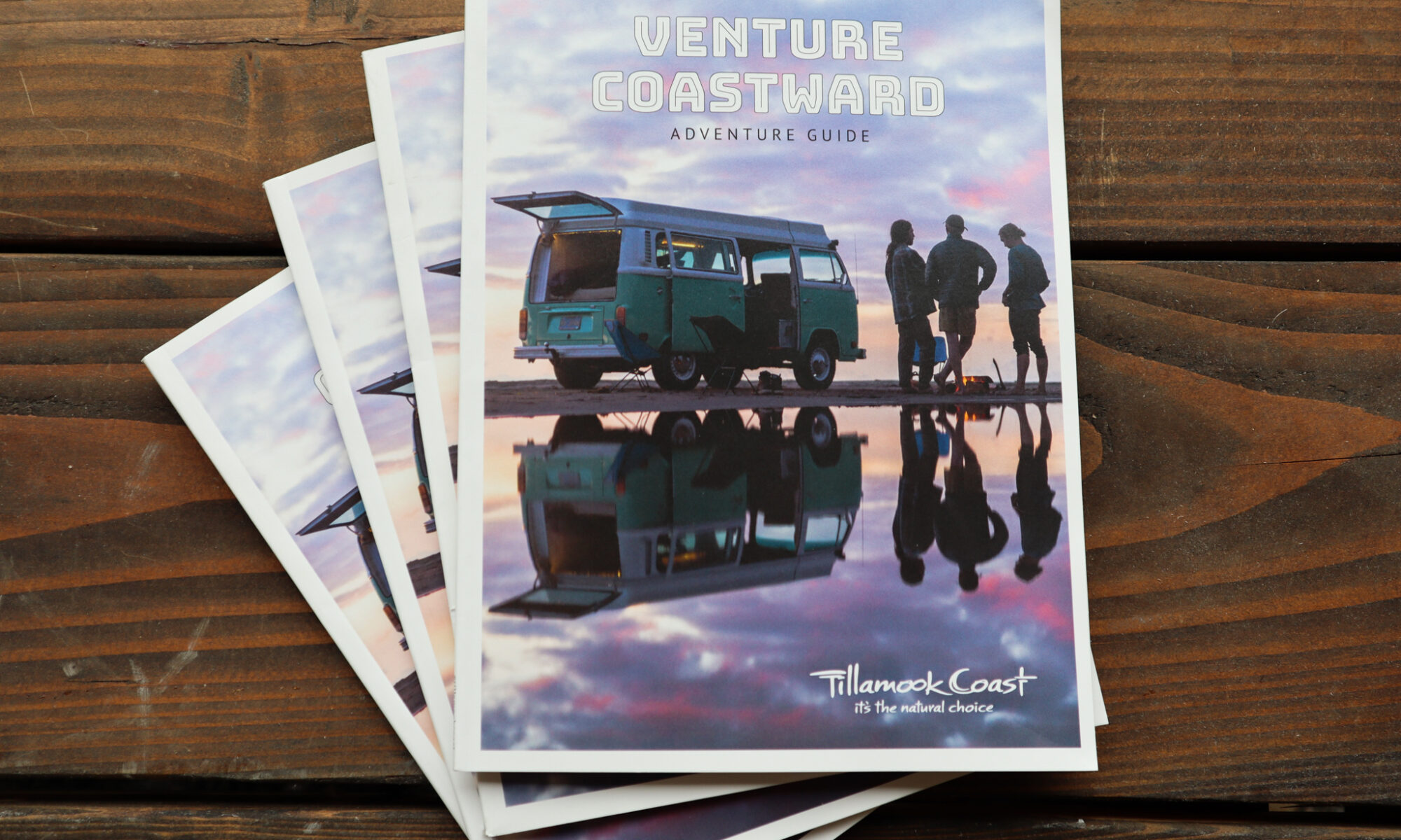 Guide cover. Blue Volkswagen Bus with the back open sits on the beach with a purple and orange sunset background. Three friends gather around a small fire.